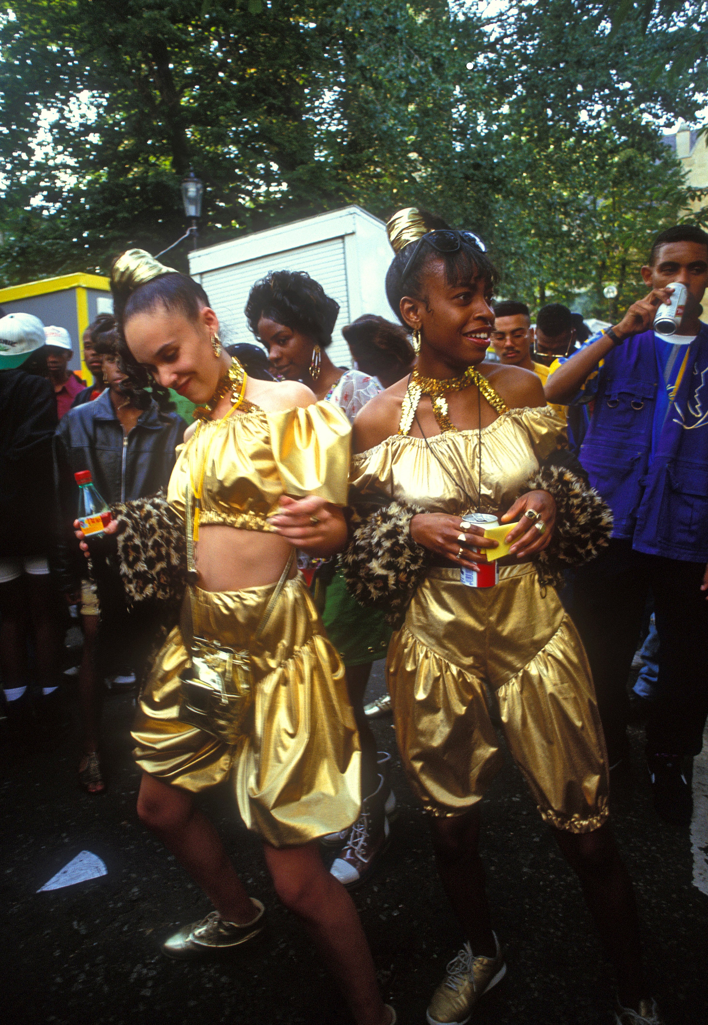 Two girls dressed in gold dancing at Notting Hill Carnival, 1993 © Giles Moberly
